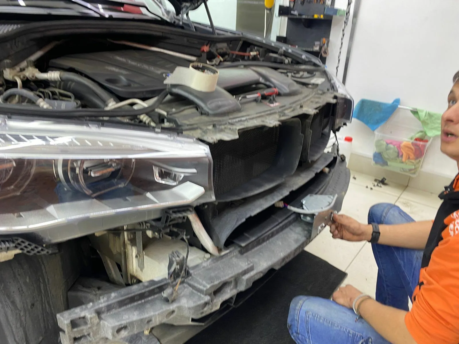 Мастер устанавливает механизм за бампером