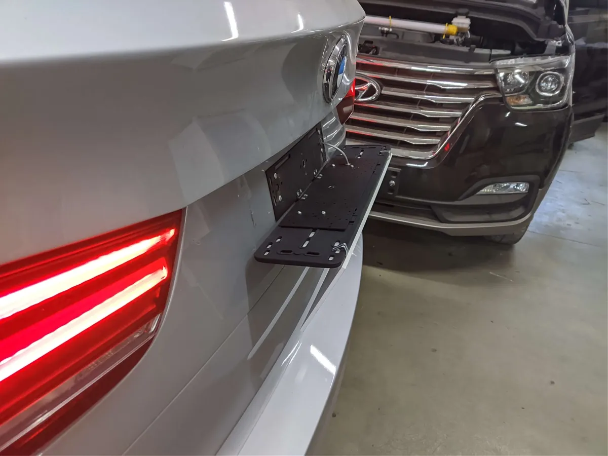 BMW — задний номер, рамка откинута, механизм виден